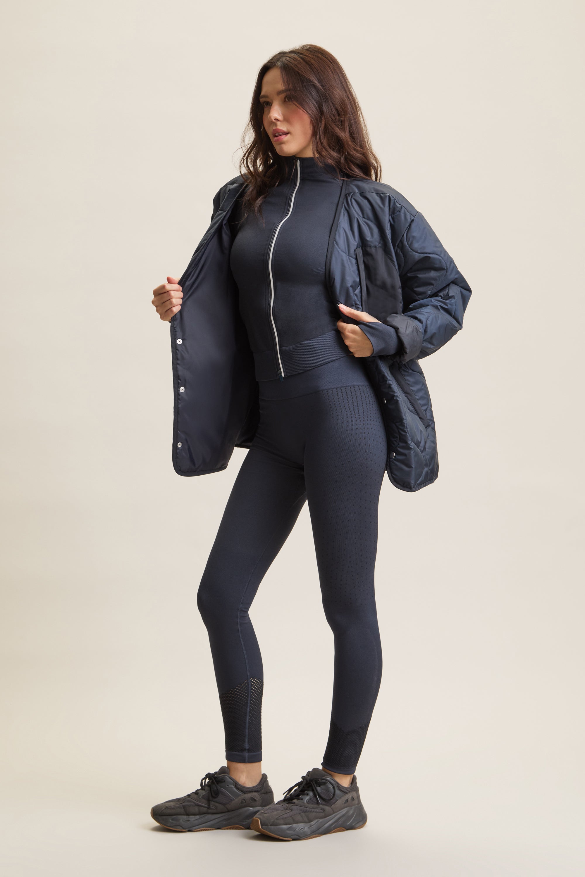 Women's HRMN8 navy dark blue wave-quilted jacket with chest pocket and side pockets, lightweight layering piece for athleisure, streetwear, and activewear. Versatile, breathable, and ideal for transitional weather and everyday movement.