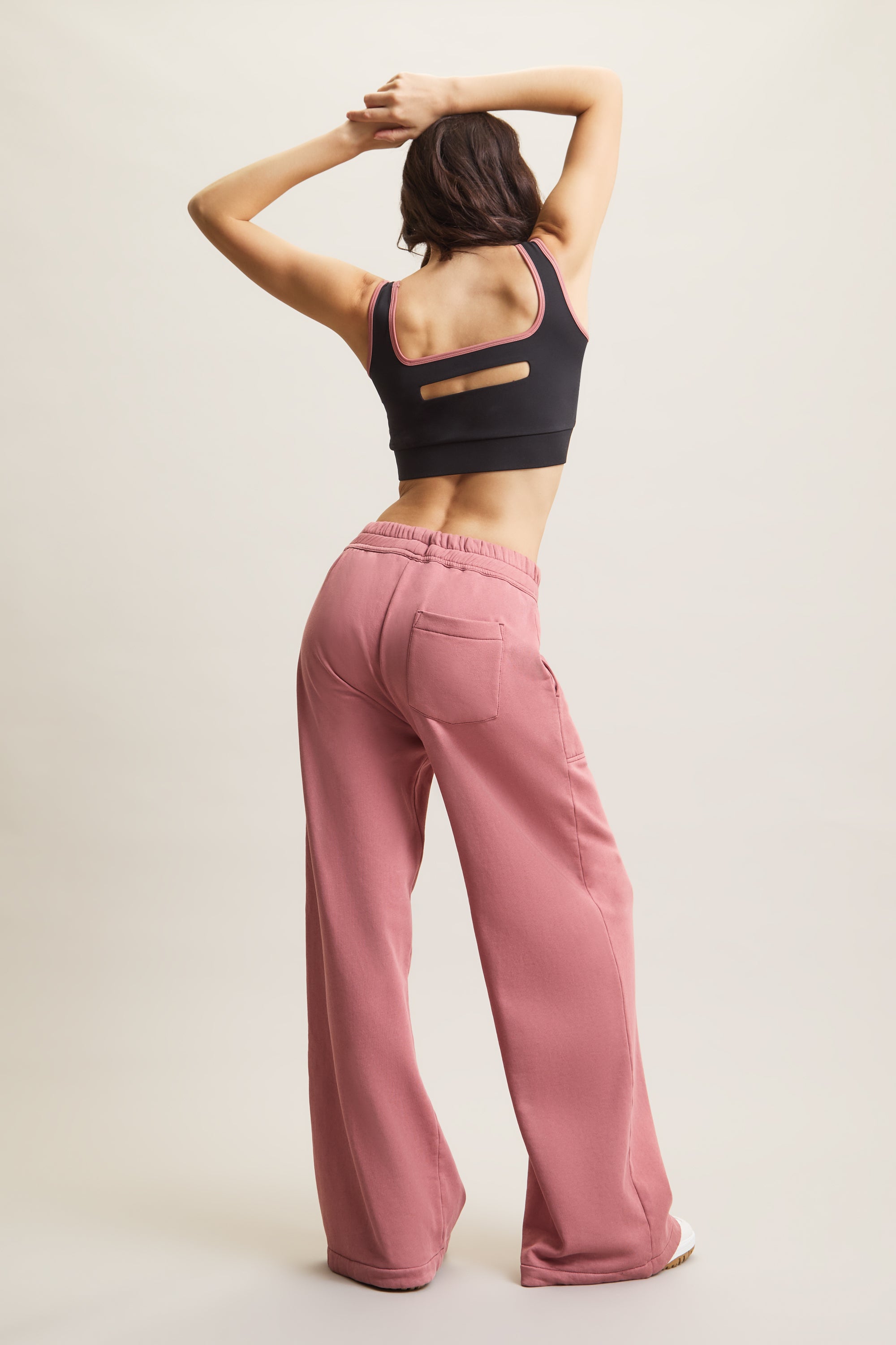 Women's HRMN8 dusty pink wide-leg joggers with adjustable drawstring waist, fleece lining, and side pockets and black cropped top