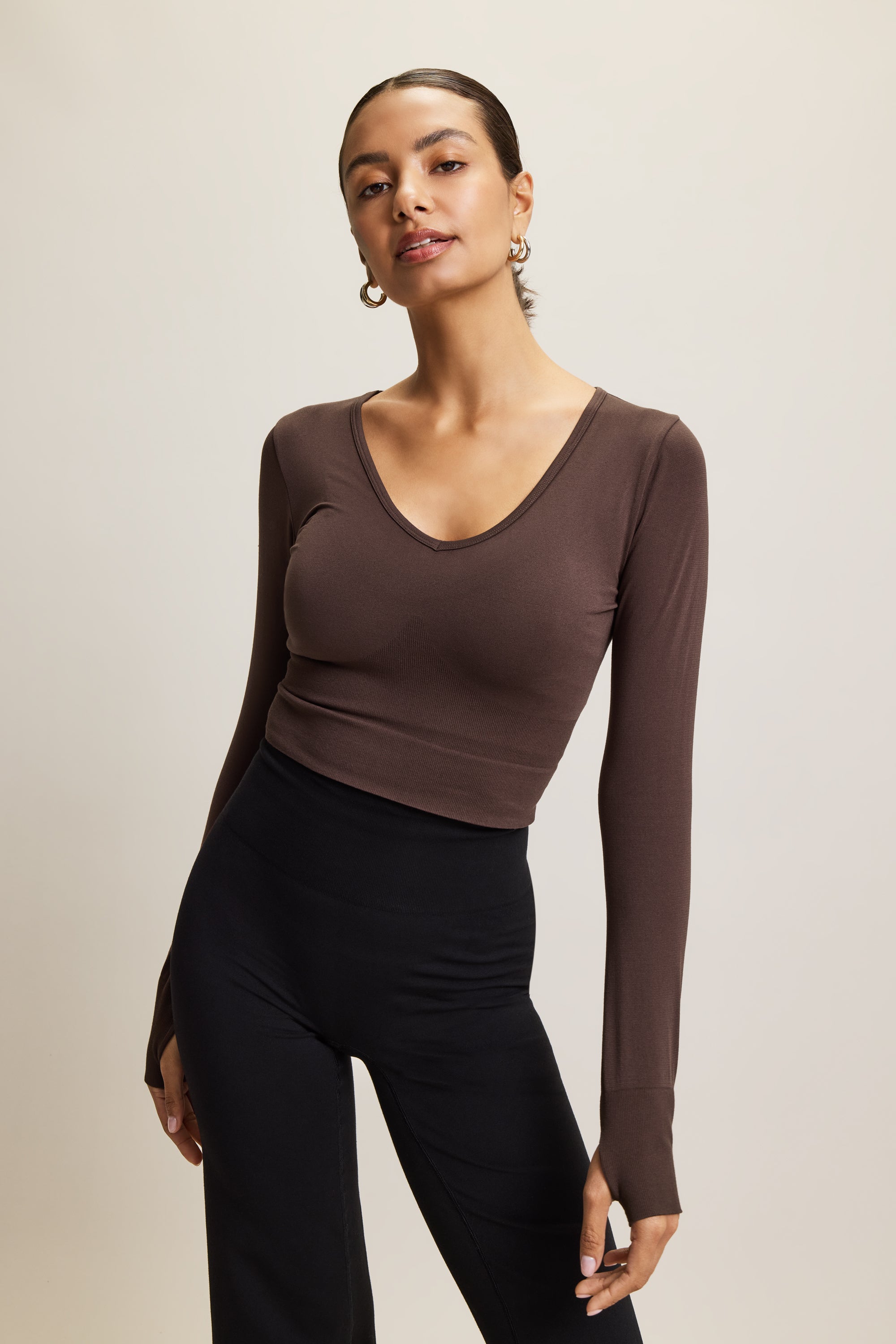 brown stylish cropped long-sleeve athleisure top made from eco-friendly bamboo fabric, featuring a flattering V-neckline, thumbholes for added comfort, and contouring panels for a sculpted fit. Perfect for activewear, this moisture-wicking and breathable top is ideal for workouts, yoga, and casual everyday outfits.