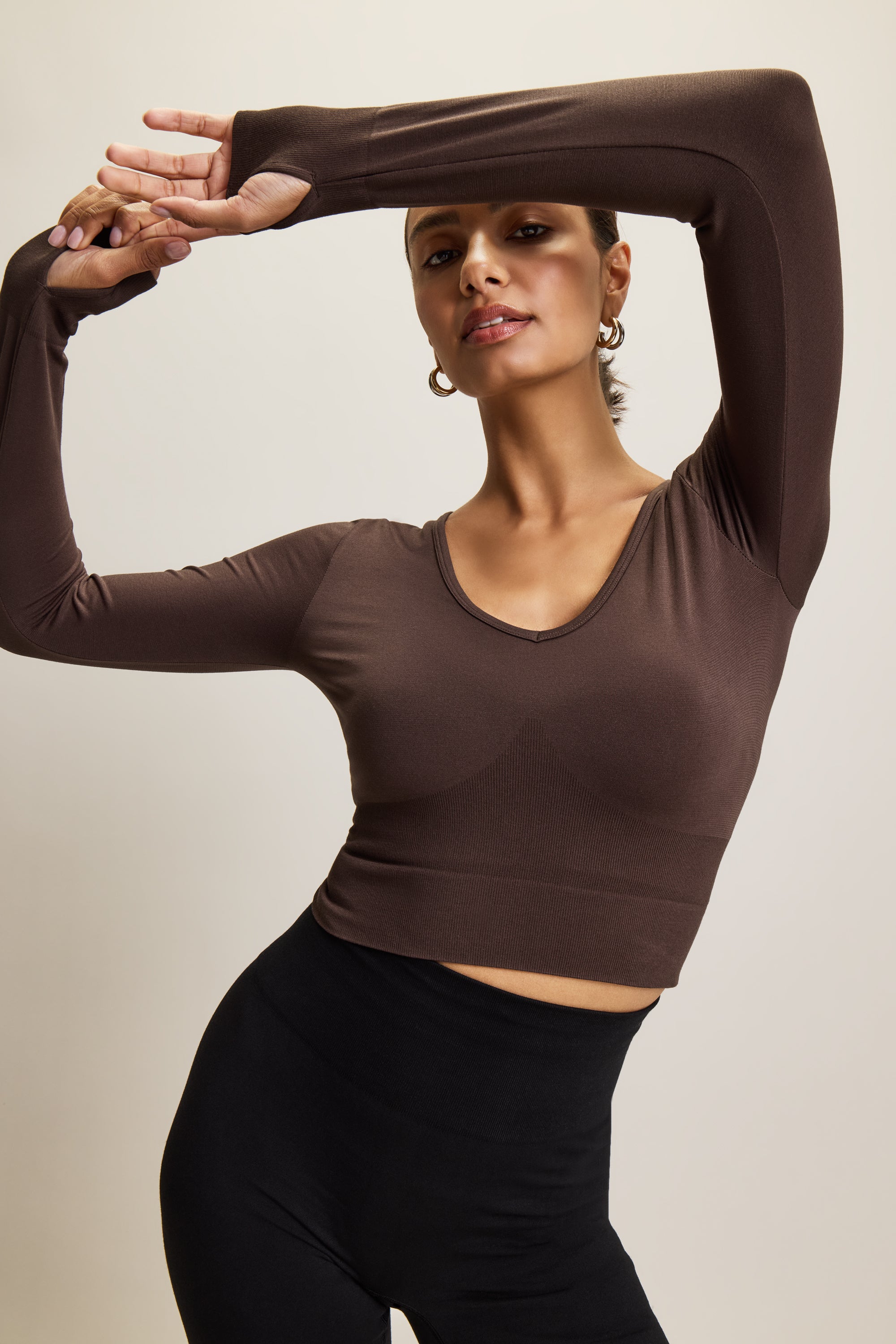 brown stylish cropped long-sleeve athleisure top made from eco-friendly bamboo fabric, featuring a flattering V-neckline, thumbholes for added comfort, and contouring panels for a sculpted fit. Perfect for activewear, this moisture-wicking and breathable top is ideal for workouts, yoga, and casual everyday outfits.