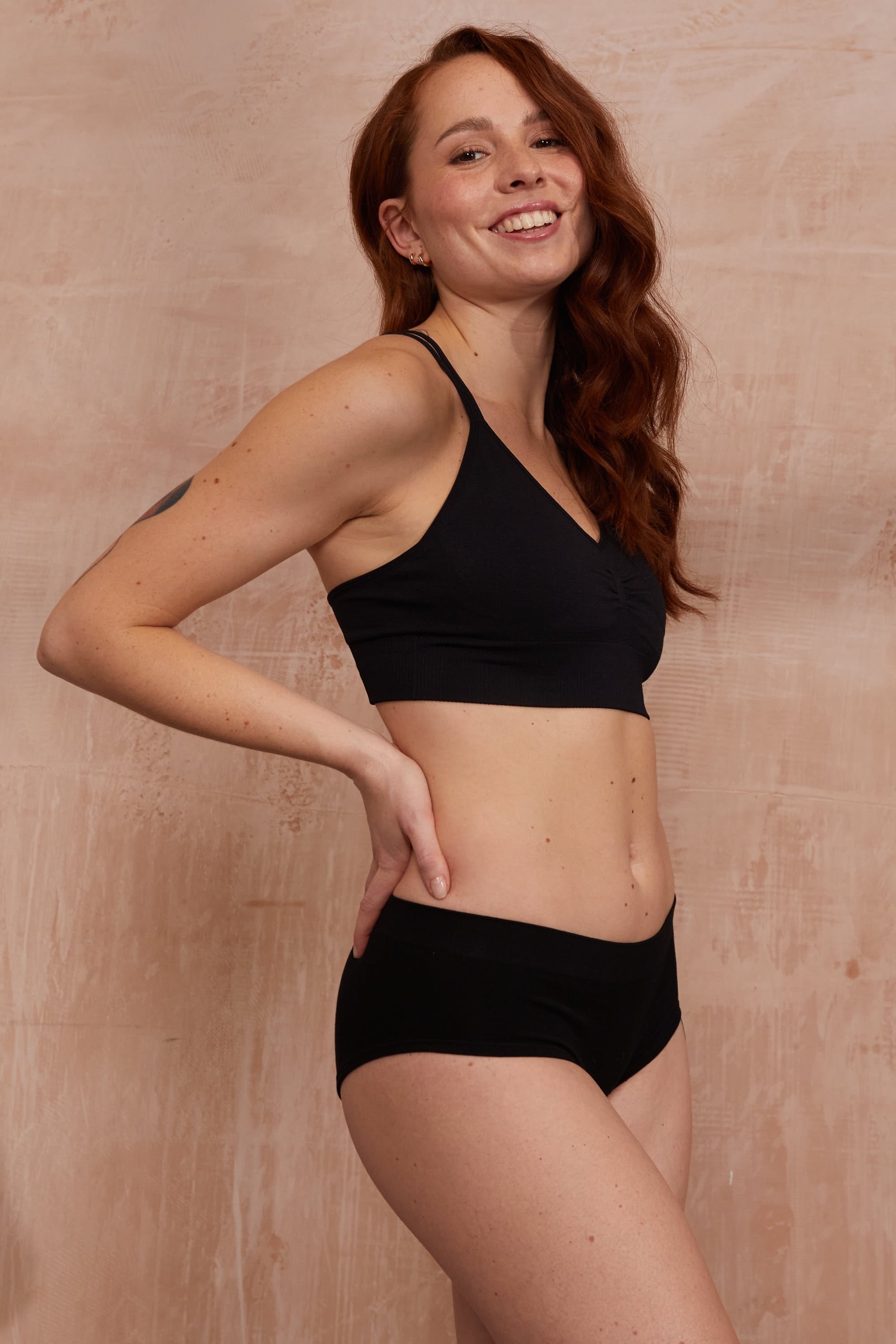 Model wearing black bra and black briefs.